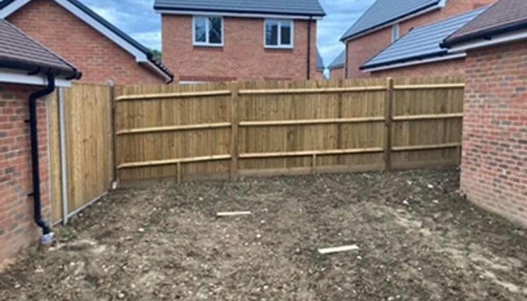 Before: A bare dirt garden plot between brick houses in Andover, ready for Clarke's Construction.